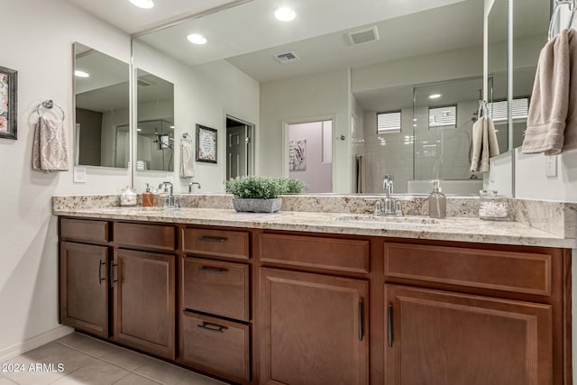 bathroom with tile patterned flooring, vanity, and a shower with shower door