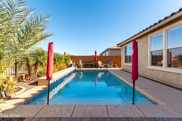 view of swimming pool featuring cooling unit and a patio