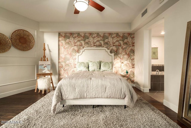 bedroom featuring dark hardwood / wood-style flooring, connected bathroom, and ceiling fan