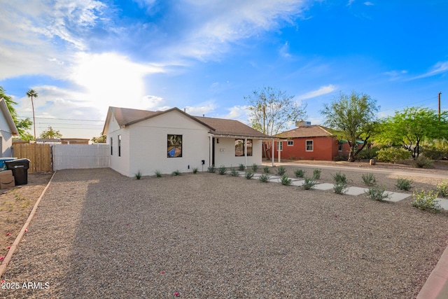 view of front facade with brick siding, fence, and driveway