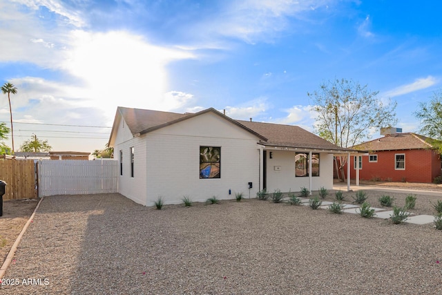 view of front of home featuring brick siding and fence