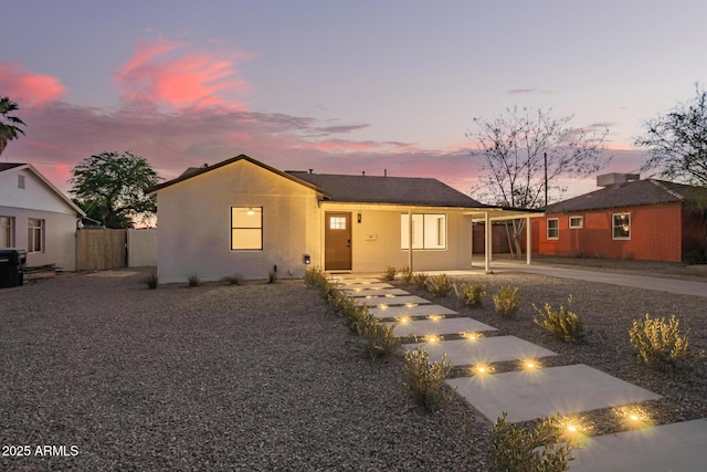 ranch-style home with fence, driveway, a fire pit, and a carport