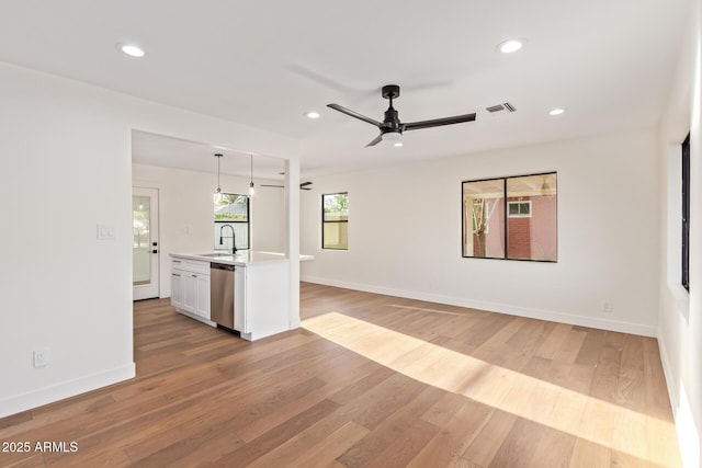 unfurnished living room with visible vents, a sink, recessed lighting, a ceiling fan, and light wood finished floors