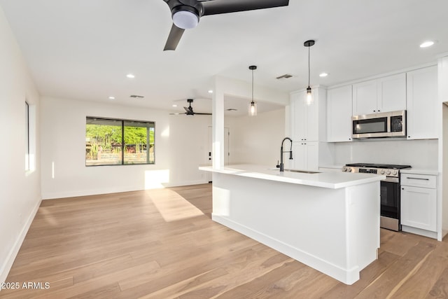 kitchen featuring a ceiling fan, visible vents, a sink, open floor plan, and stainless steel appliances
