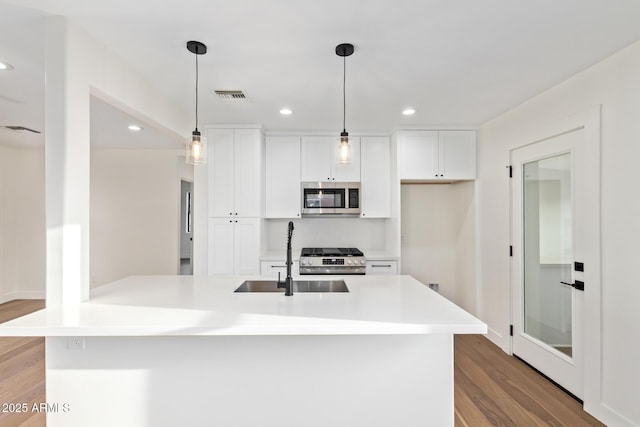 kitchen featuring a sink, appliances with stainless steel finishes, white cabinetry, and visible vents