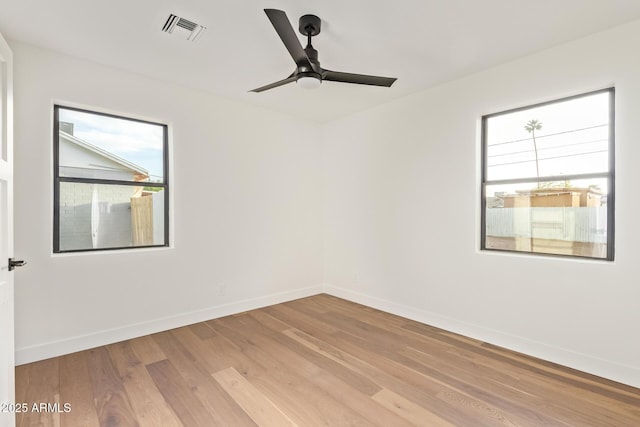 empty room with visible vents, baseboards, plenty of natural light, and light wood-type flooring