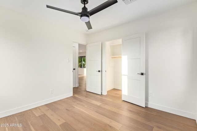 unfurnished bedroom with baseboards, ceiling fan, a closet, and light wood-style flooring
