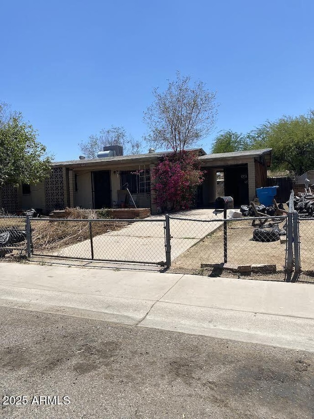 ranch-style home featuring a fenced front yard and concrete driveway