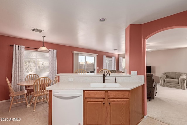 kitchen with light carpet, sink, white dishwasher, and hanging light fixtures