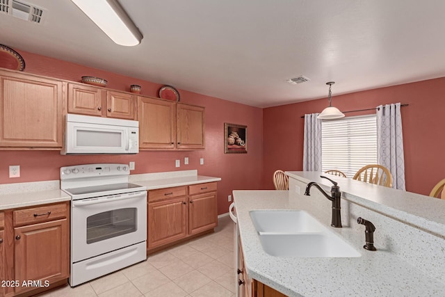 kitchen featuring light stone countertops, sink, decorative light fixtures, white appliances, and light tile patterned floors