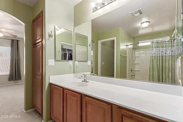 bathroom featuring vanity, shower / tub combo with curtain, and ceiling fan