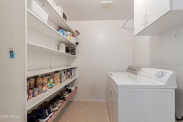 washroom featuring cabinets, separate washer and dryer, and light tile patterned flooring