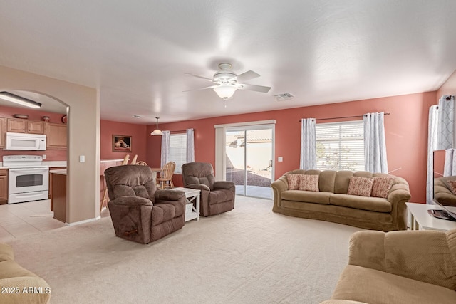 carpeted living room with ceiling fan