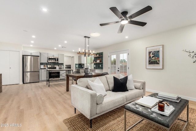 living room featuring french doors, ceiling fan, sink, and light wood-type flooring