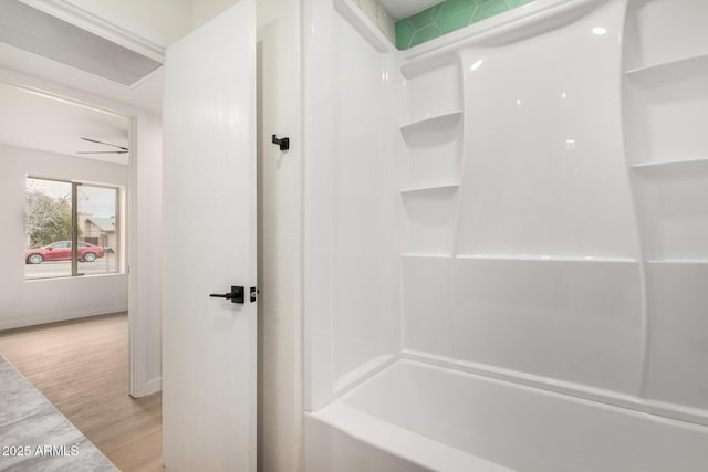 bathroom featuring hardwood / wood-style flooring and washtub / shower combination