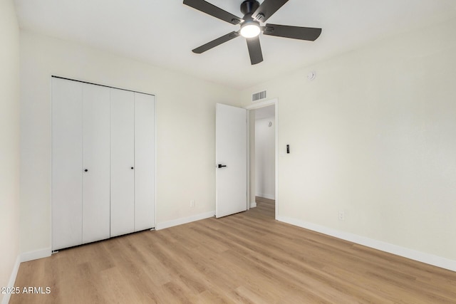 unfurnished bedroom with ceiling fan, light hardwood / wood-style floors, and a closet