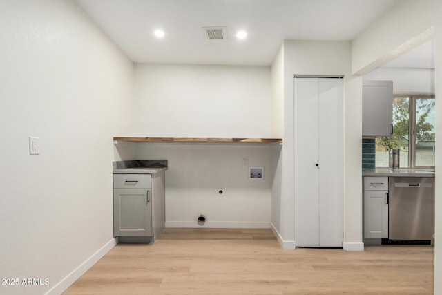 washroom featuring electric dryer hookup, hookup for a washing machine, and light hardwood / wood-style floors