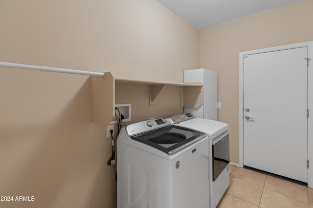 laundry room with washing machine and dryer and light tile patterned flooring