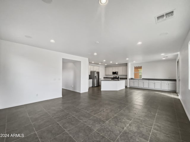 unfurnished living room featuring dark tile patterned floors