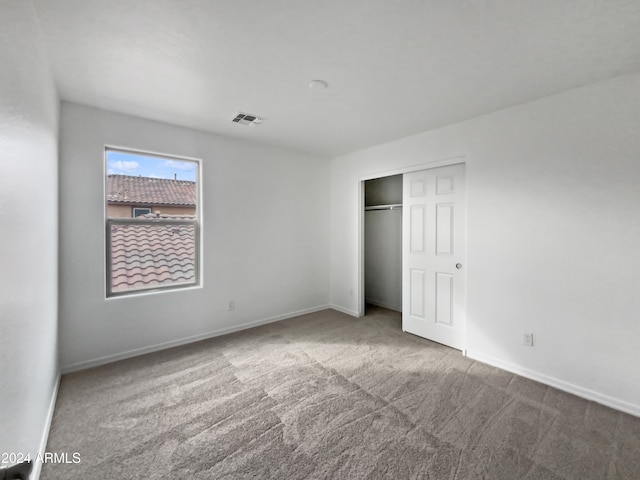 unfurnished bedroom featuring carpet floors and a closet