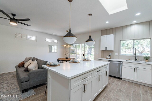 kitchen with white cabinets, plenty of natural light, a center island, and dishwasher