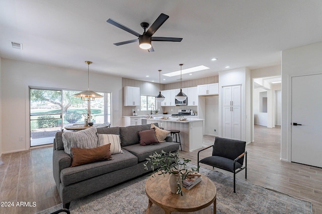 living room with light wood-type flooring and ceiling fan