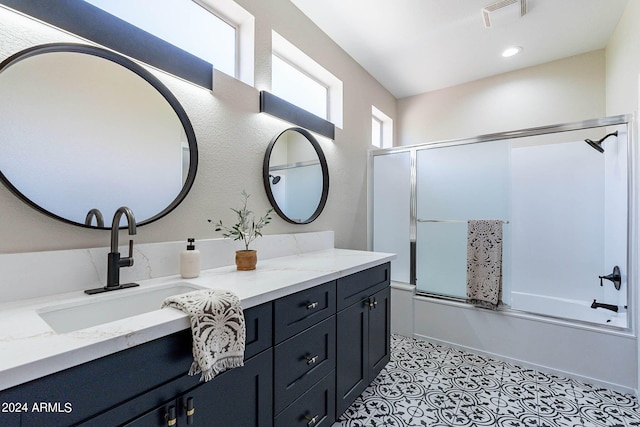 full bath featuring tile patterned flooring, visible vents, vanity, and combined bath / shower with glass door