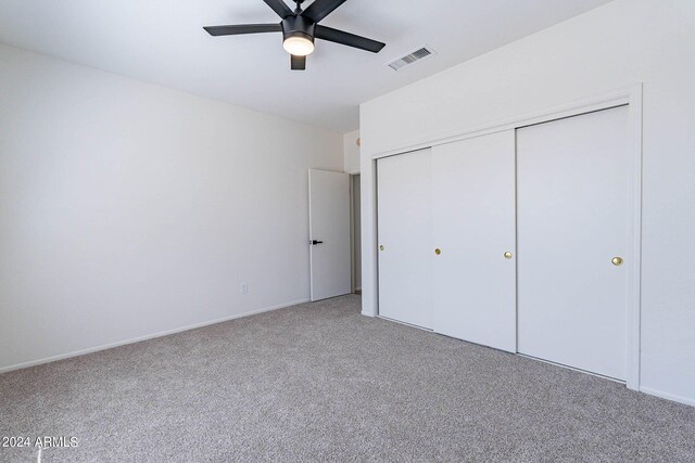 unfurnished bedroom featuring carpet floors, ceiling fan, and a closet