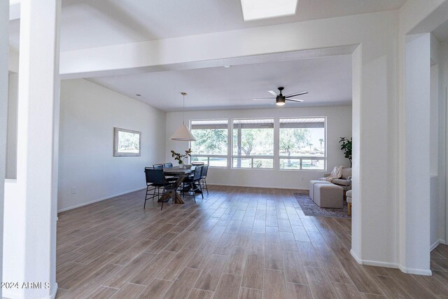 interior space with hardwood / wood-style flooring, a skylight, and ceiling fan