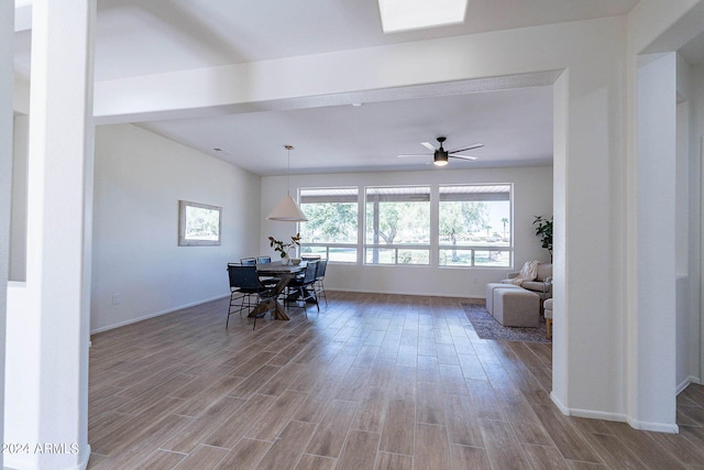 dining room featuring ceiling fan, wood finished floors, and baseboards