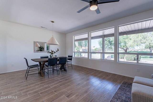 dining space with ceiling fan and wood-type flooring