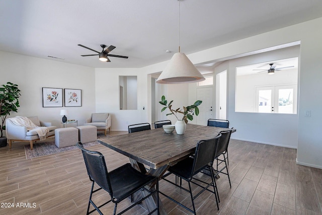 dining area featuring wood tiled floor, visible vents, ceiling fan, and baseboards