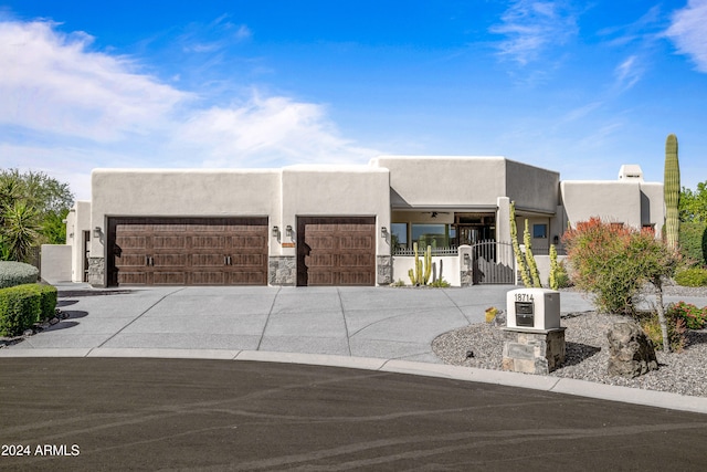 pueblo revival-style home with a garage