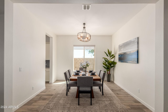 dining area featuring light hardwood / wood-style flooring and an inviting chandelier