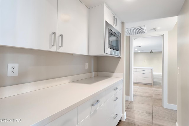 kitchen featuring stainless steel microwave and white cabinets