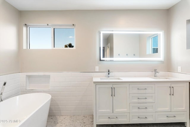 bathroom featuring tile walls, a bathtub, and vanity