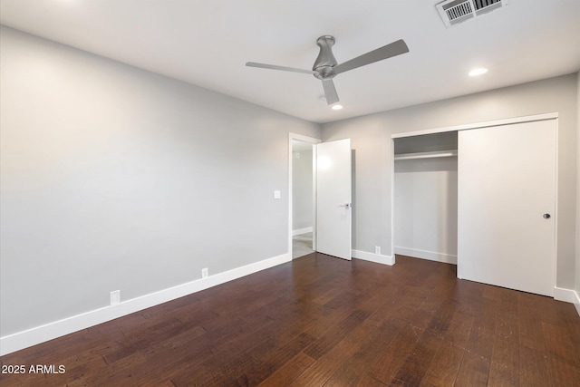 unfurnished bedroom featuring ceiling fan, a closet, and dark wood-type flooring