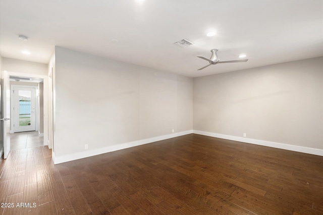 empty room with ceiling fan and dark hardwood / wood-style flooring