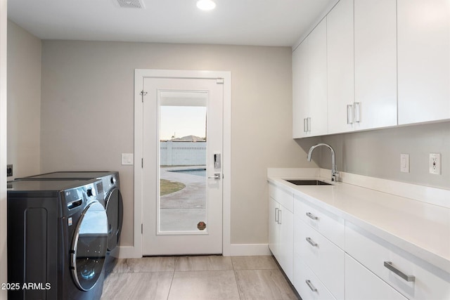 laundry area featuring washer and dryer, light tile patterned floors, sink, and cabinets