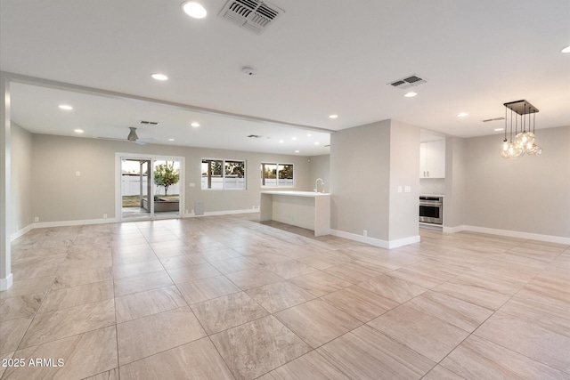 unfurnished living room featuring ceiling fan