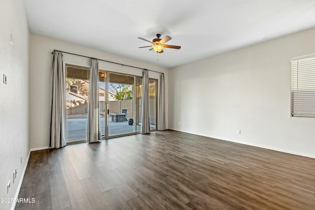 empty room featuring ceiling fan, baseboards, and dark wood-type flooring