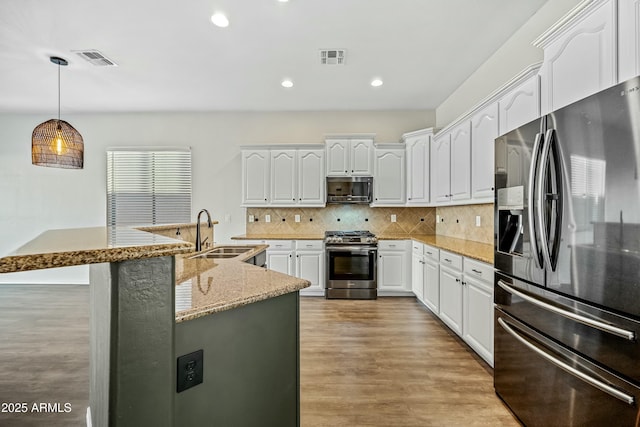 kitchen featuring light wood finished floors, visible vents, appliances with stainless steel finishes, and a sink