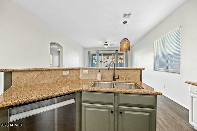 kitchen with arched walkways, a sink, visible vents, stainless steel dishwasher, and tasteful backsplash