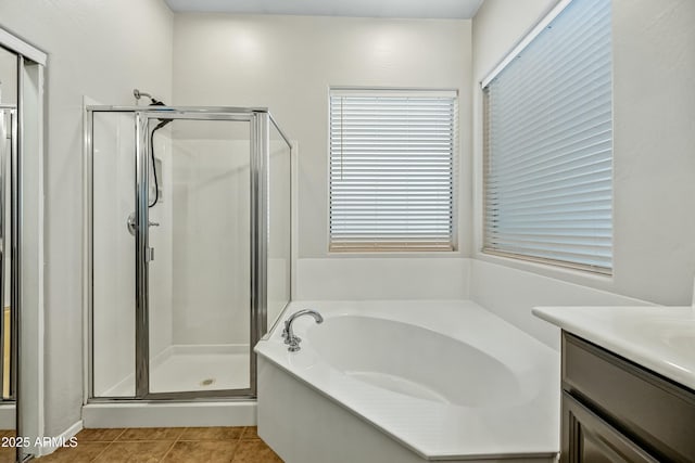 bathroom featuring a stall shower, a garden tub, vanity, and tile patterned floors