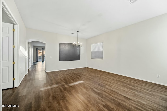 interior space with baseboards, visible vents, arched walkways, dark wood-style flooring, and an inviting chandelier