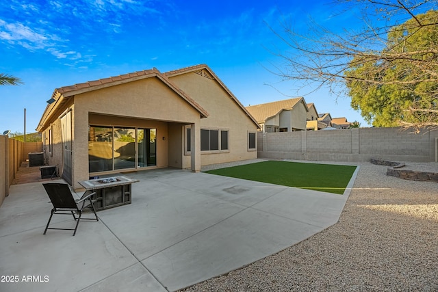 rear view of property with an outdoor fire pit, central AC unit, a patio, a fenced backyard, and stucco siding