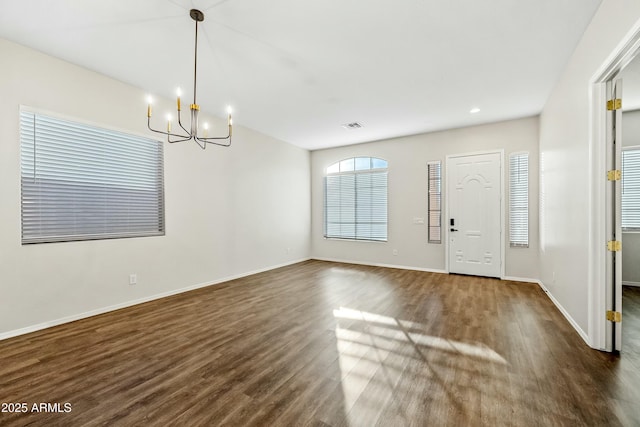 entrance foyer with a notable chandelier, visible vents, baseboards, and dark wood-type flooring