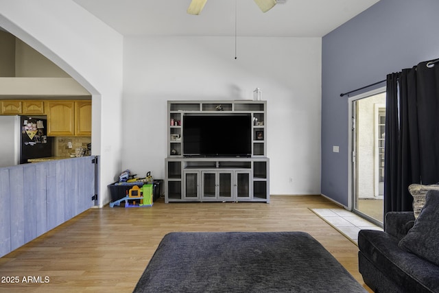 7832 E Osage Ave, Mesa, AZ 85212 - living area featuring a high ceiling, arched walkways, ceiling fan, and light wood-style flooring