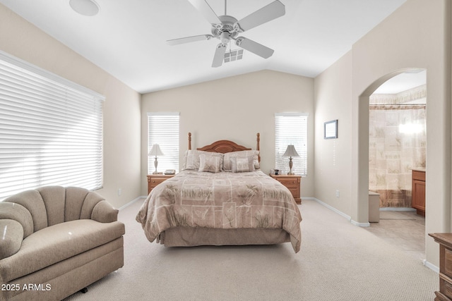 carpeted bedroom with vaulted ceiling, ceiling fan, and ensuite bathroom