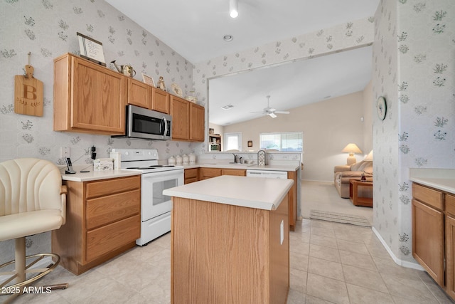 kitchen featuring sink, light tile patterned floors, white electric stove, a kitchen island, and ceiling fan